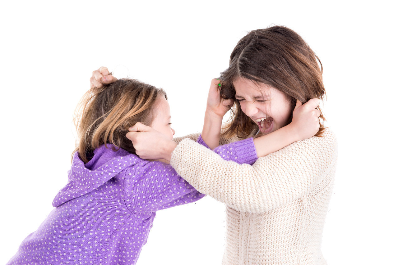 Young girls fighting, pulling hairs isolated in white