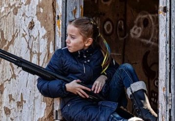 Το κορίτσι με το όπλο και το γλυφιτζούρι: Ο συμβολισμός μίας ερασιτεχνικής φωτό που κάνει τον γύρο του κόσμου (εικόνες)